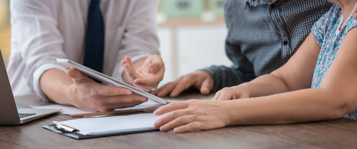 Man showing couple something on a tablet