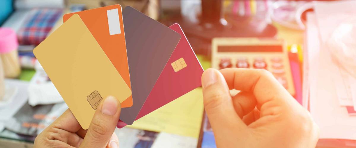Women's hand holding 4 credit cards. Select a specific focus