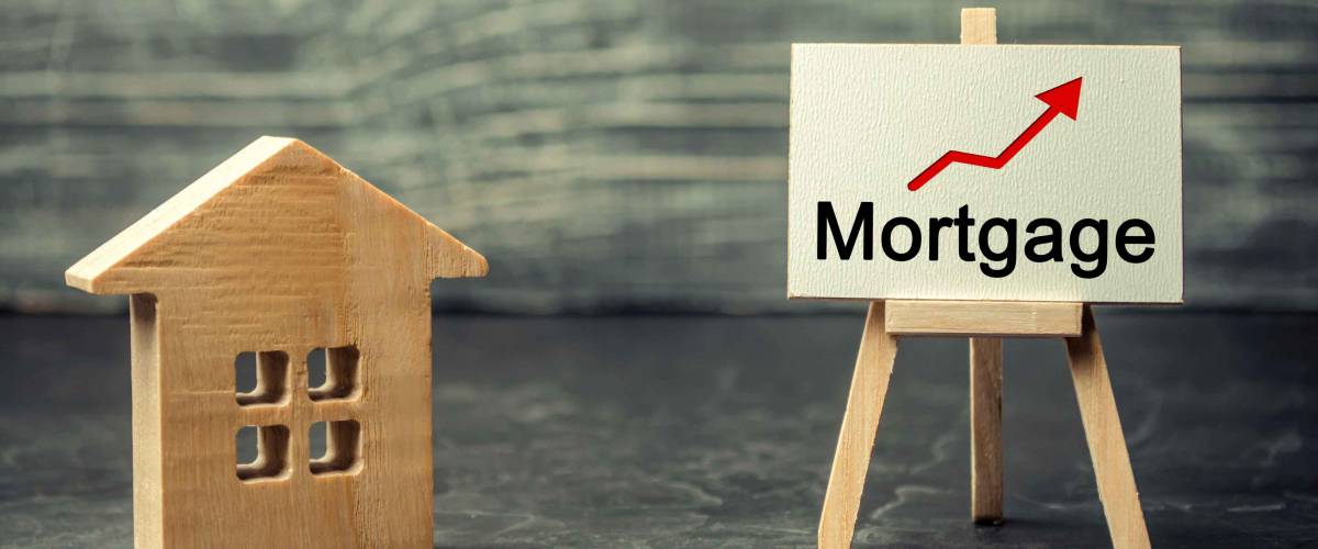 Wooden house and the inscription Mortgage and up arrow. Raising mortgage rates and tax. The increase in interest charges. Reduced demand for housing. Loan for housing, apartment and property.