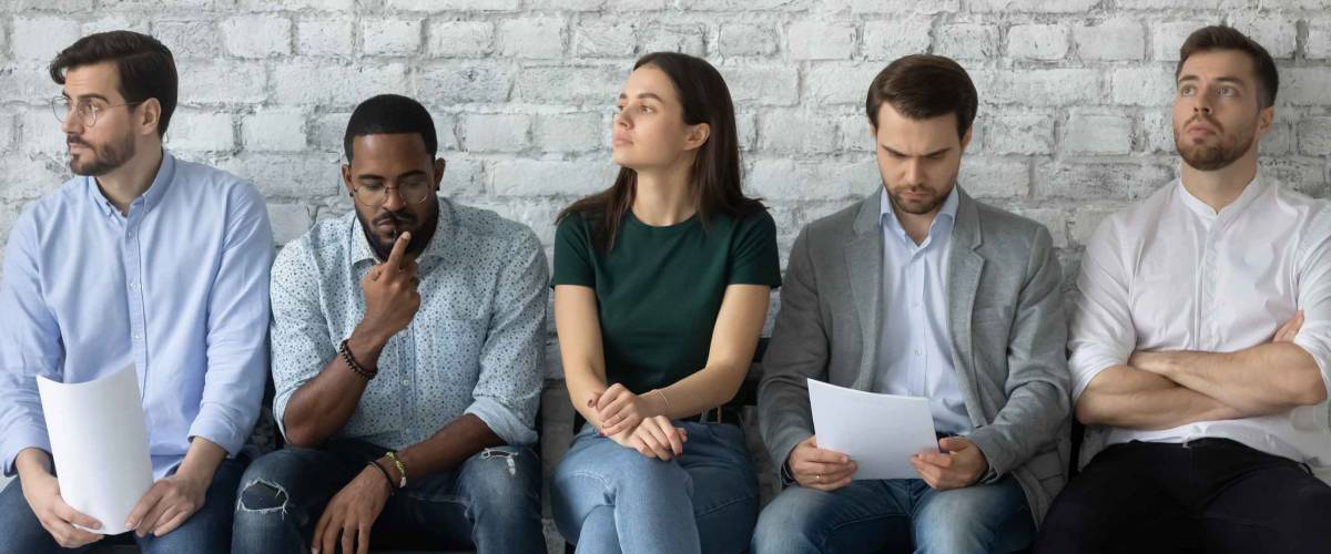 Five unemployed millennials wait their turn for a job interview.