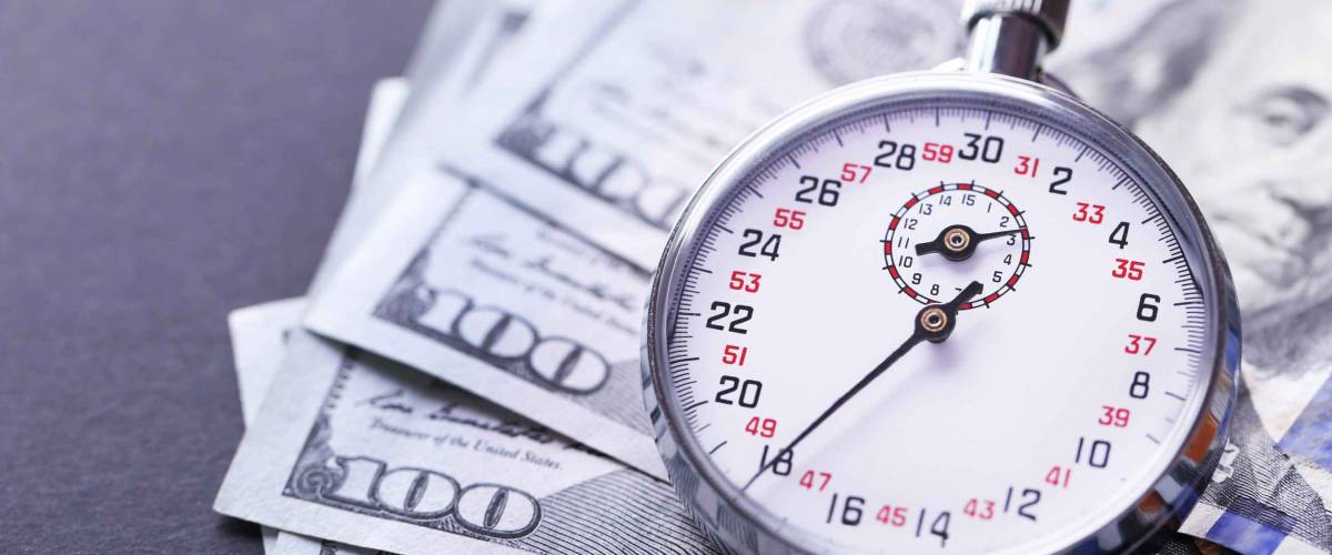 Stopwatch with money on black background.