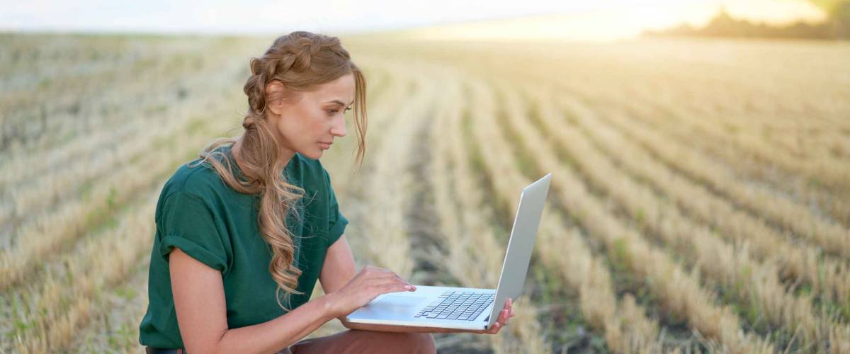 Woman farmer smart farming standing farmland smiling using laptop Female agronomist specialist research monitoring analysis data agribusiness Caucasian worker agricultural field