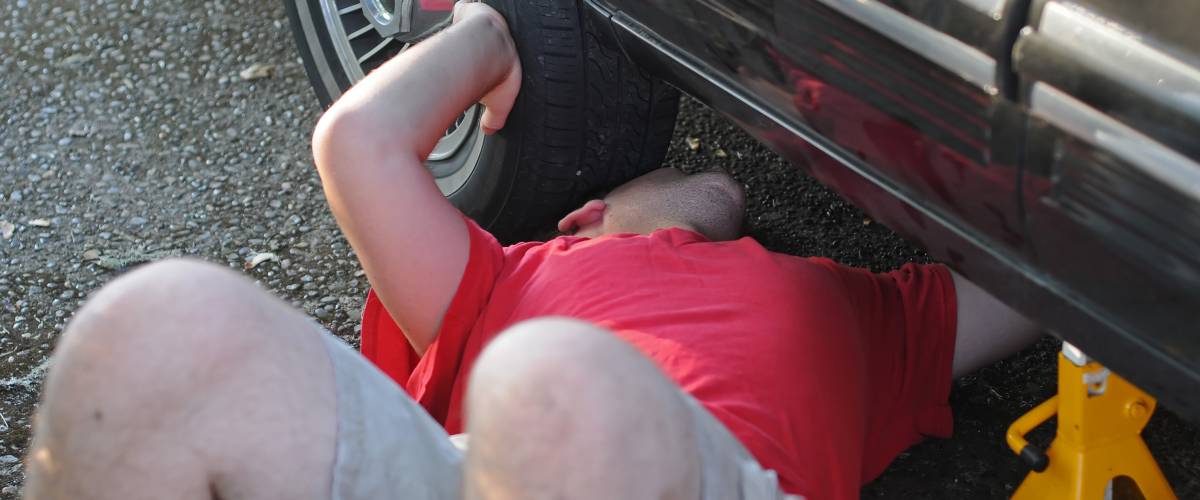 A man underneath a car.