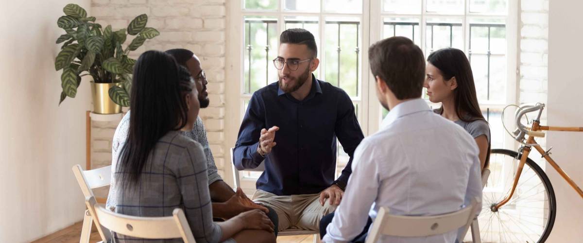 Male counselor speak at group therapy session