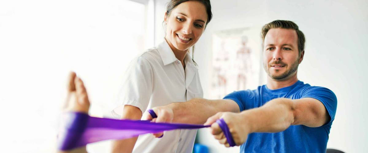 A physiotherapist doing treatment with patient in bright office
