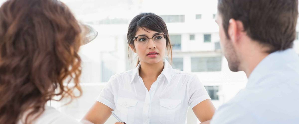 Therapist listening her patients and taking notes in the office