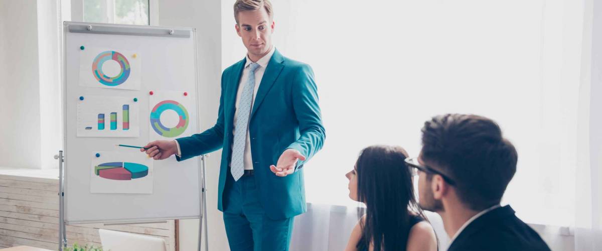 Young manager presenting whiteboard to his colleagues about financial growth