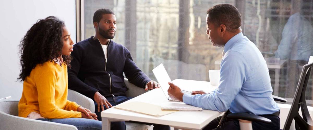 Couple Meeting With Male Financial Advisor Relationship Counsellor In Office