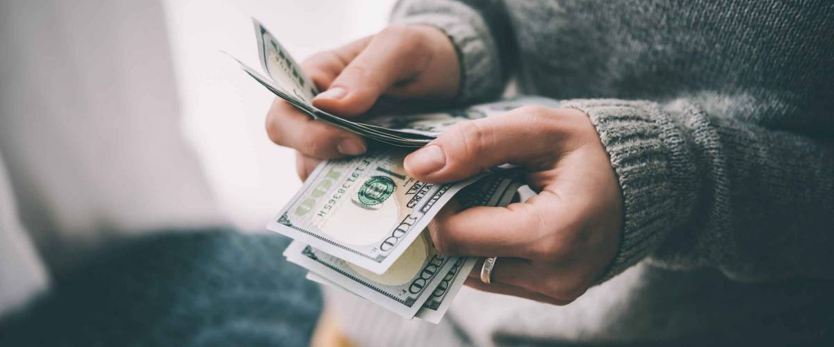 Hands counting us dollar bills. Toned picture