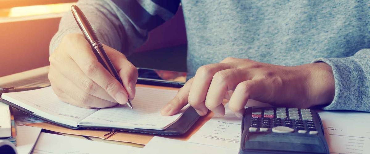 Young man doing finance in home office with calculate about cost.