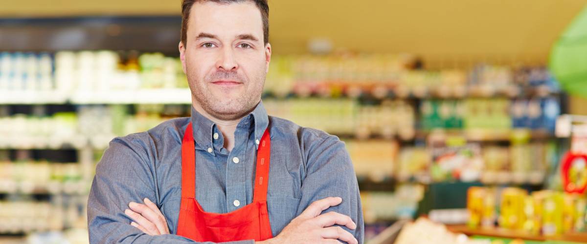 Store manager standing with his arms crossed in a supermarket