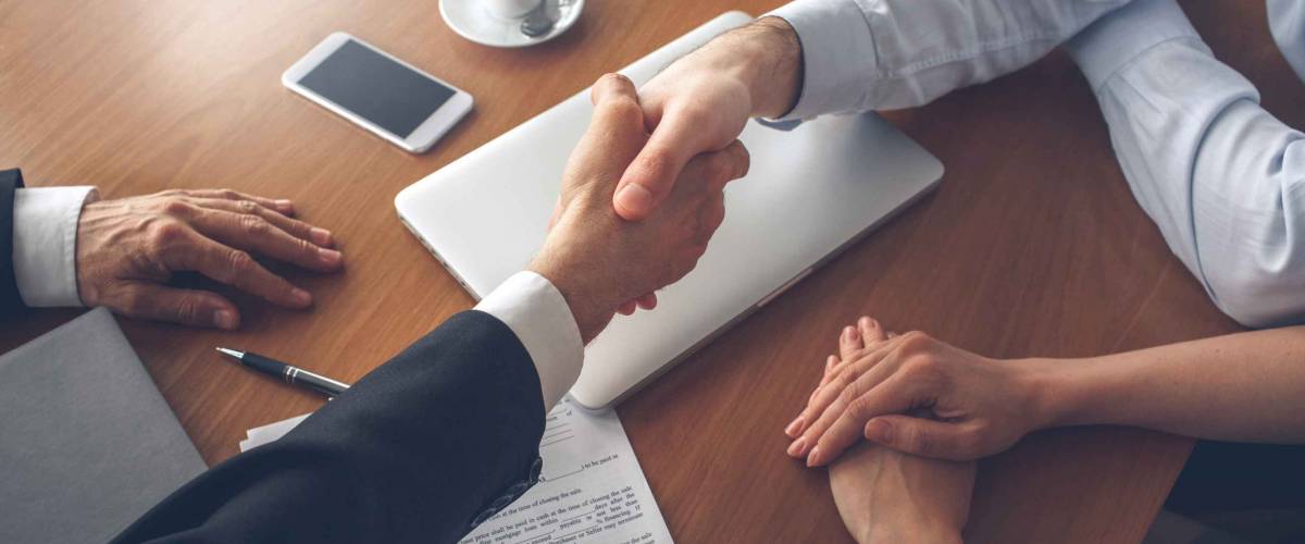 People shaking hands on a home closing day.
