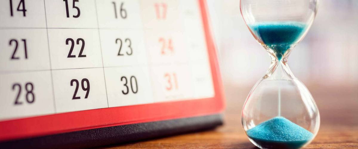 Hour glass and calendar concept for time slipping away for important appointment date, schedule and deadline