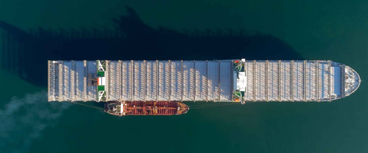 Top view of a large empty container ship and a tanker standing side by side.