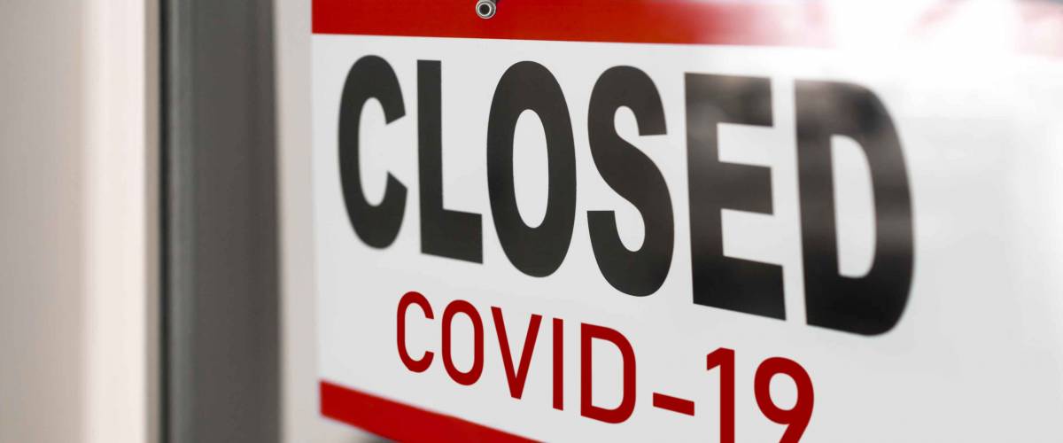 Closed businesses for COVID-19 pandemic outbreak, closure sign on retail store window.