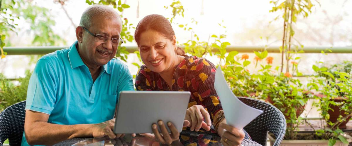 Senior couple doing home finance and checking bills with laptop.