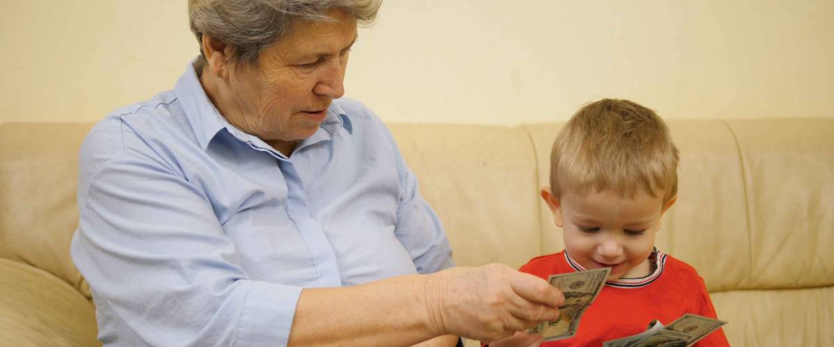 Grandmother on couch, giving little boy cash