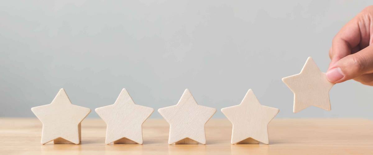 Hand putting wooden five star shape on table.