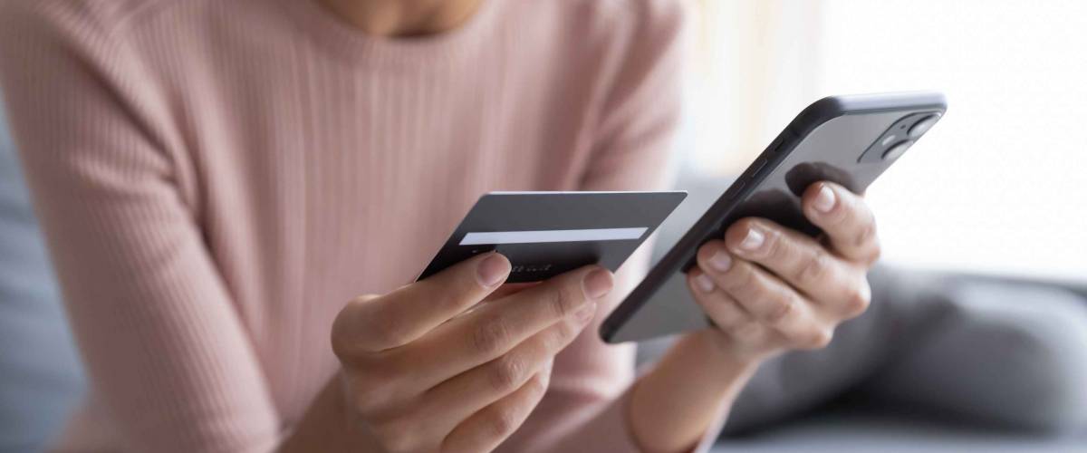 Close up female hands holding credit card and smartphone