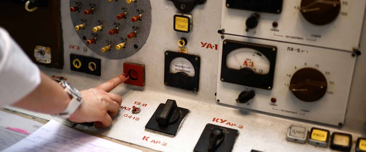 The central control room of first nuclear power plant. Fragment of nuclear reactor control panel red button