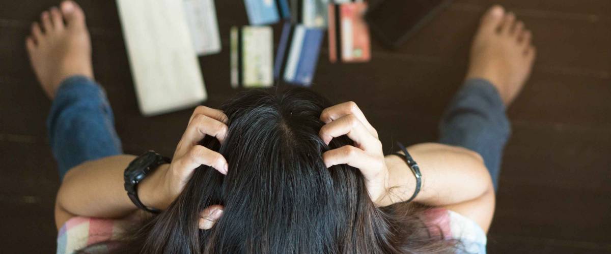 Top view of stressed young asian woman trying to find money to pay credit card debt.