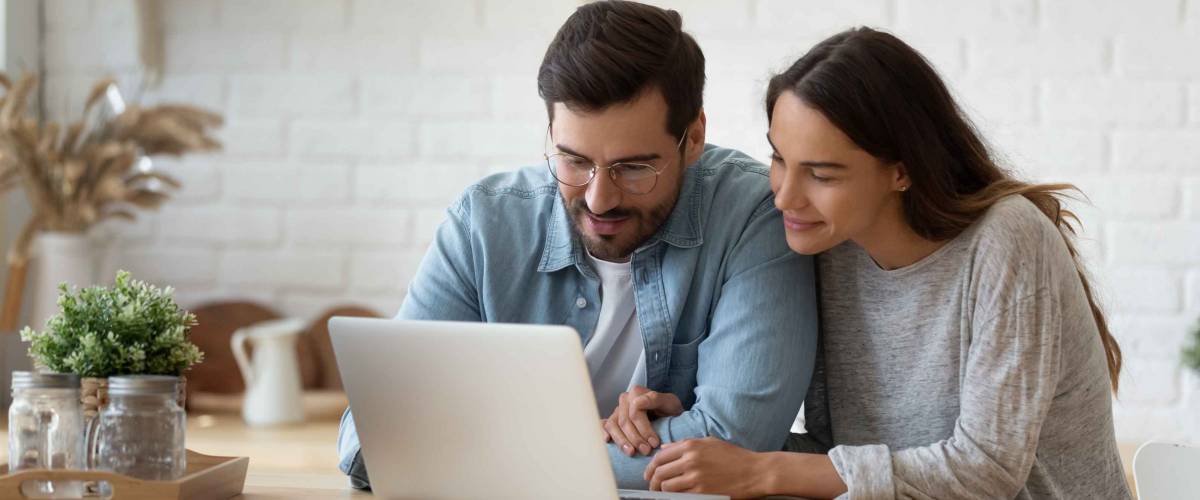 Couple looking at laptop screen.