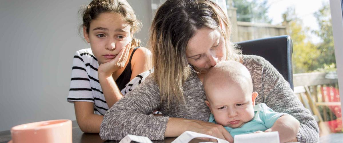 A Mother holding baby and take a look on his bill,