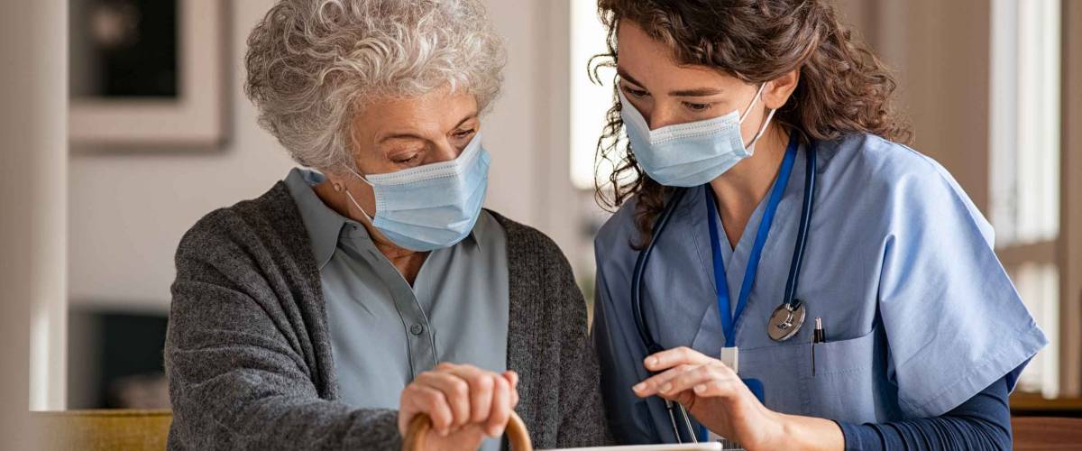 Doctor and senior woman going through medical record on digital tablet