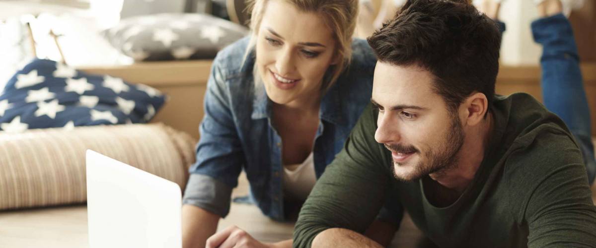 Young couple in new flat using laptop