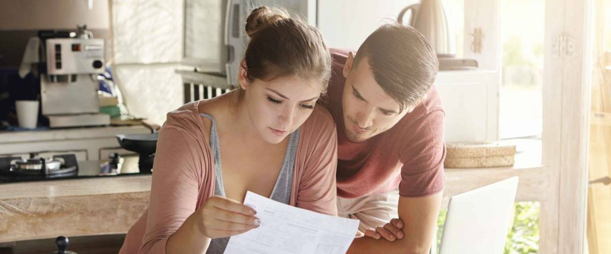 Young couple looking at finances at kitchen table