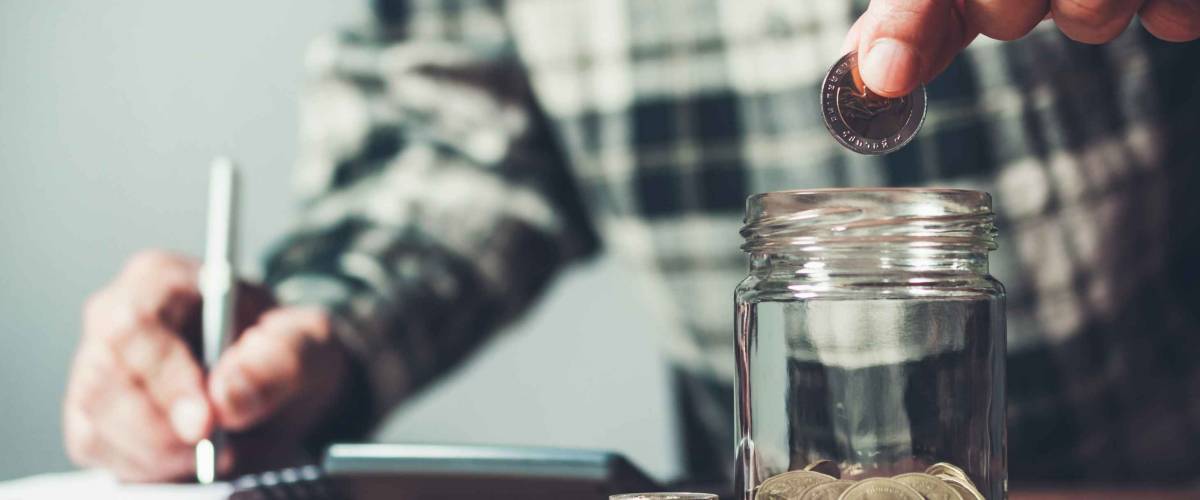 Business man putting coin in glass bottle saving bank and account for his money all in finance accounting concept.