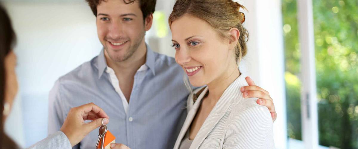 Happy young couple getting keys of their new home