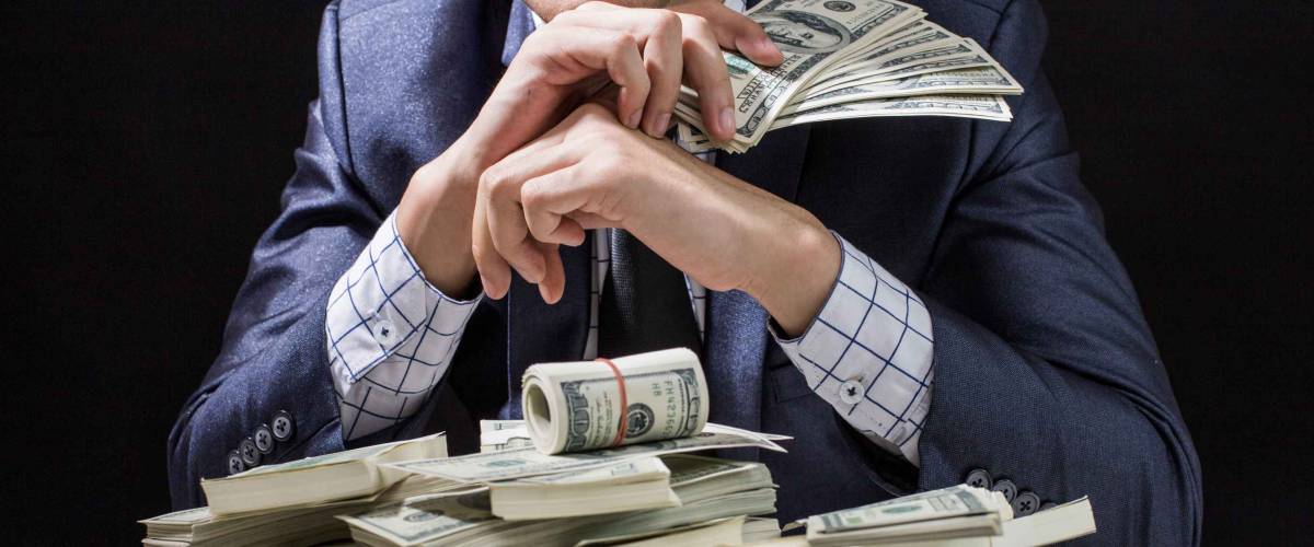 Man holding Money in hand at Black Background, Man receive a lot Money from Trading, Business Success Concept.
