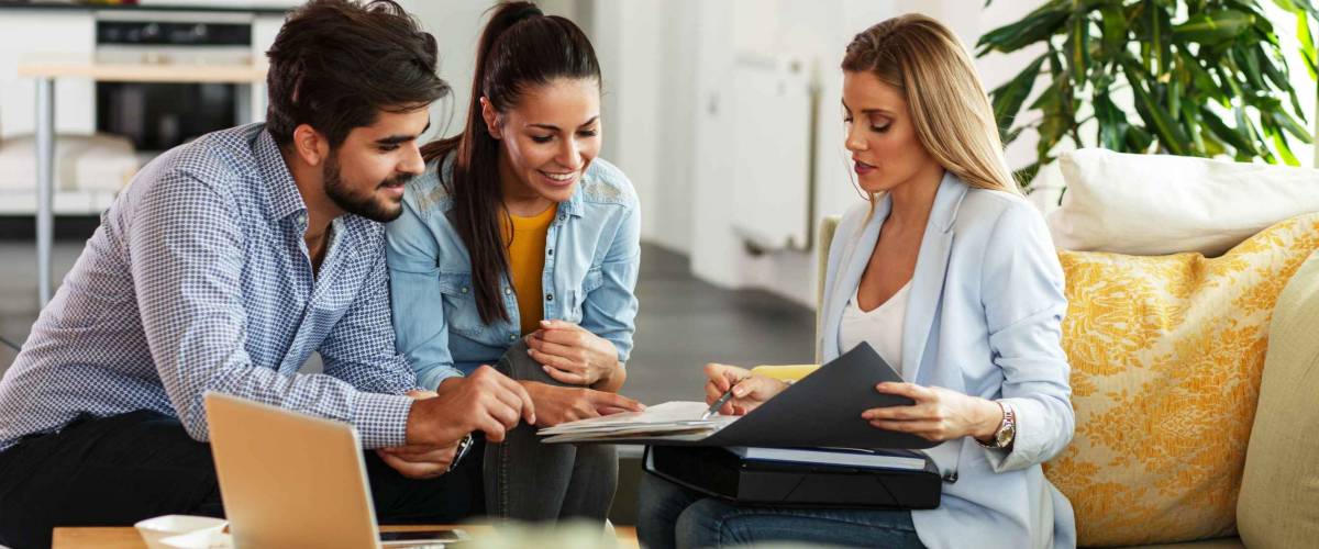 Female Real Estate agent offer home ownership and life insurance to young couple.