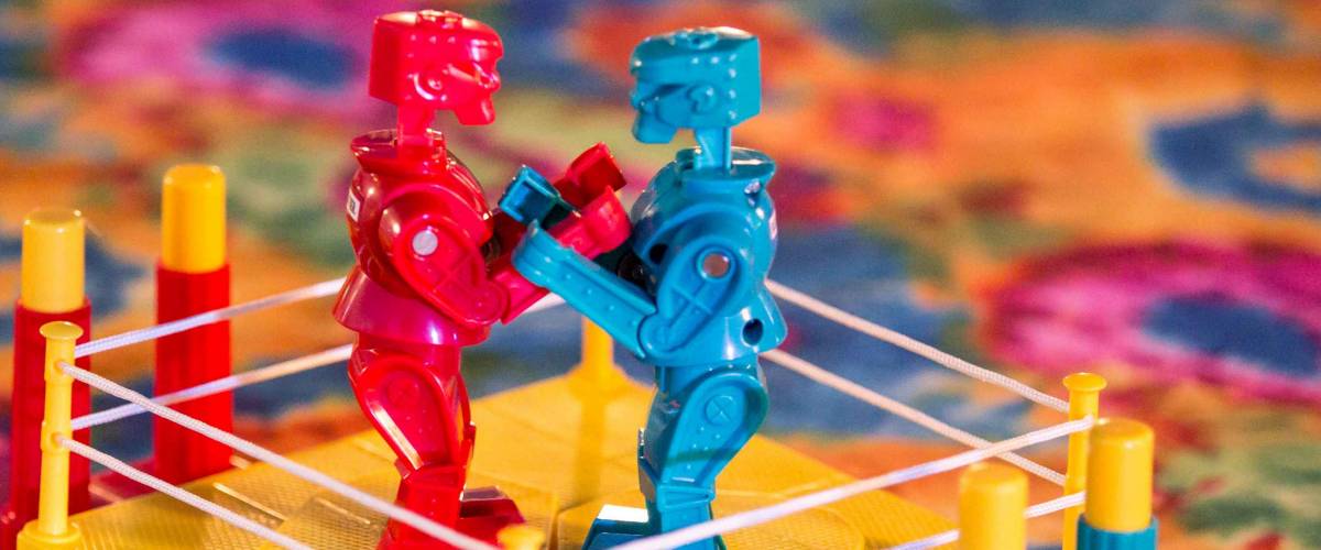 Kids brightly colored boxing robots game on multicolored table top.