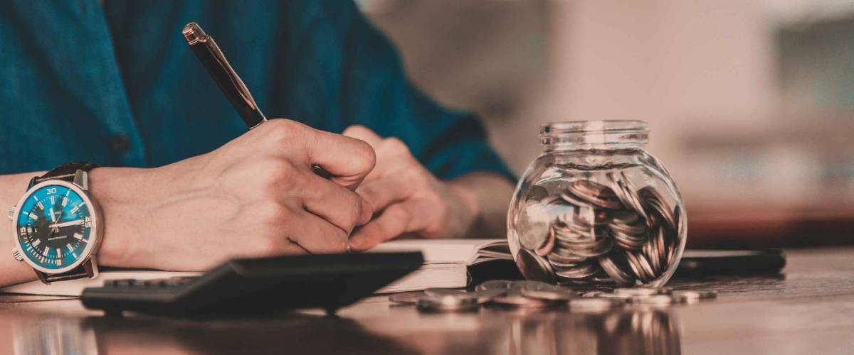 Close up of people hand work calculator and money,coins in finance banking and saving concept