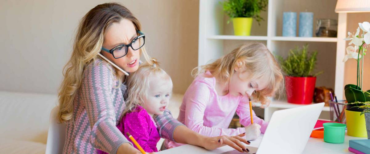 Busy woman trying to work while babysitting two kids