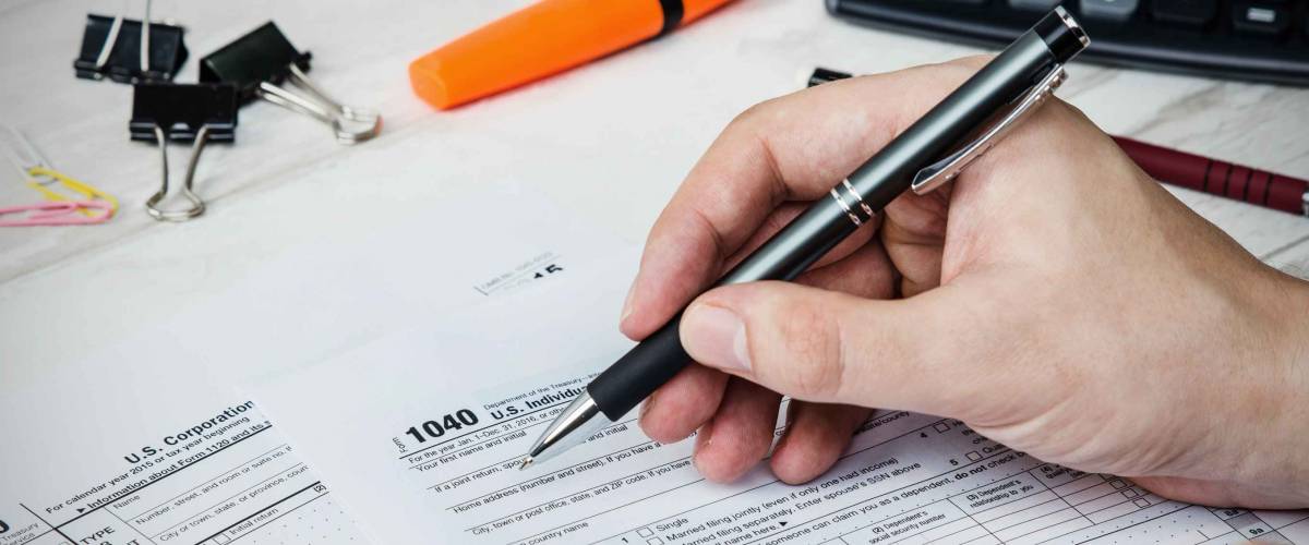 Man filling US tax form. tax form us business income office hand fill concept