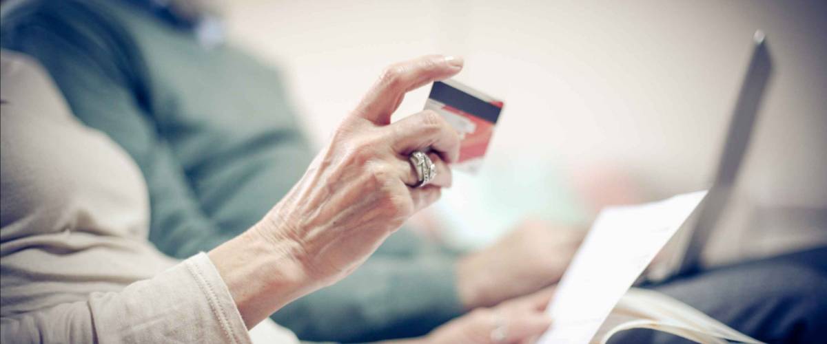 Senior couple at home checking finance on credit card.