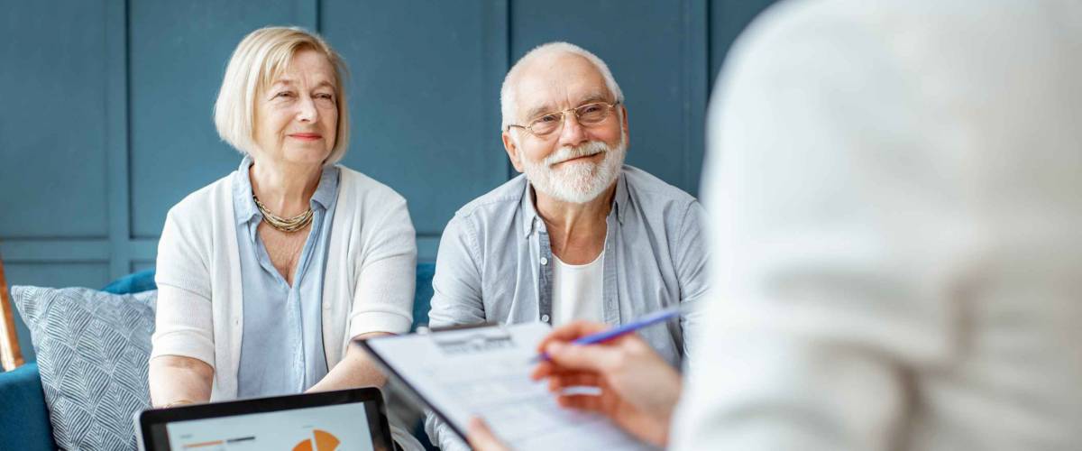 Happy senior couple during the meeting with agent or financial consultant.