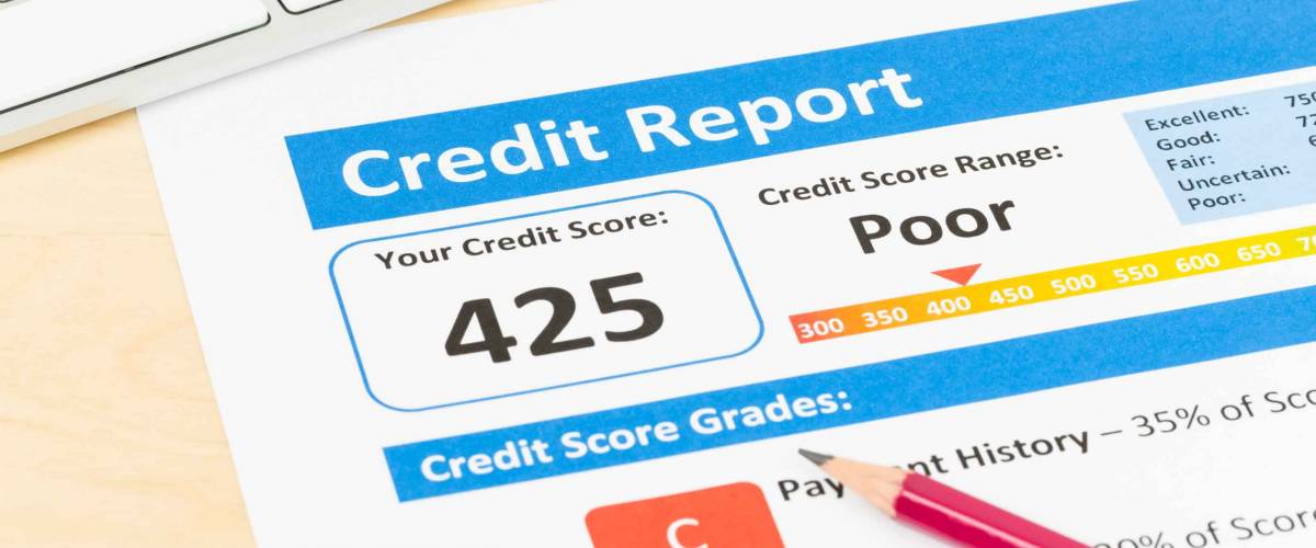 Poor credit score report with pen and keyboard
