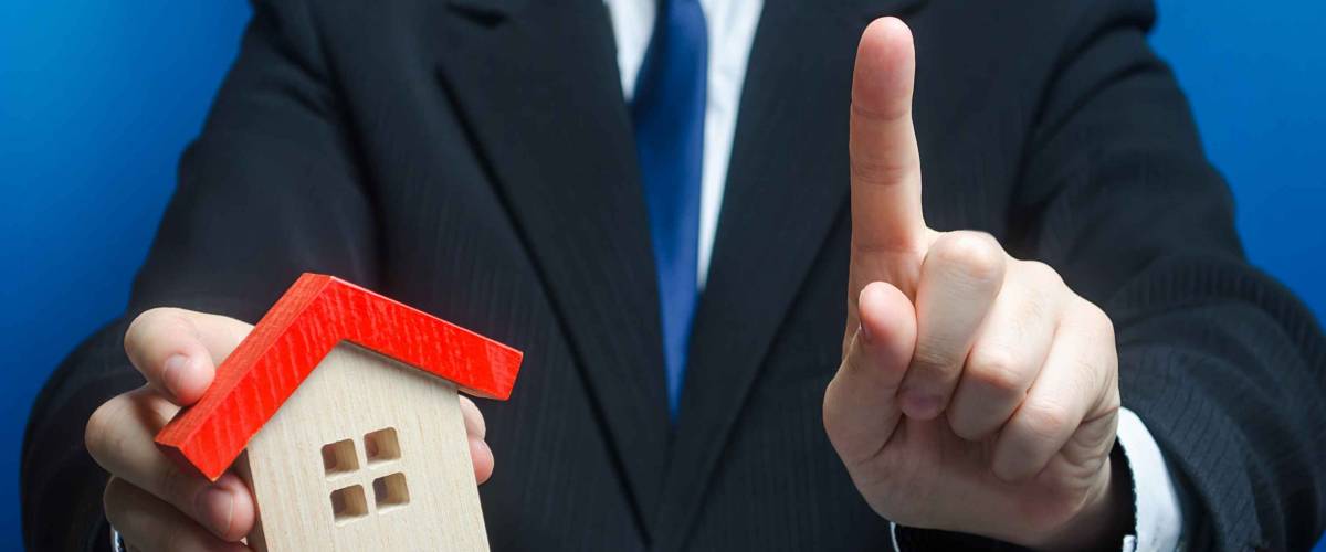 Man with a house makes a gesture of attention