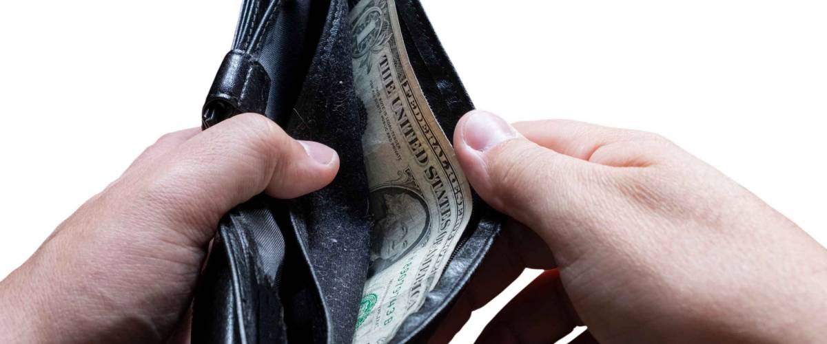 Hands holding almost empty wallet with one dollar. Poverty concept. Financial difficulties concept. Financial crisis, unemployment concept.