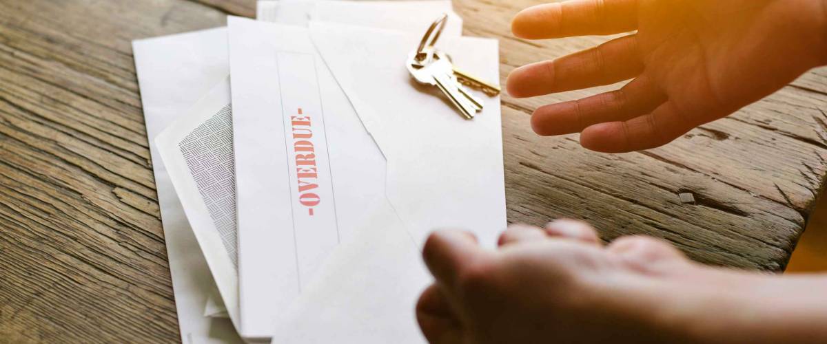 Expressive hands react to an overdue letter in an envelope - Financial hardship - Crisis