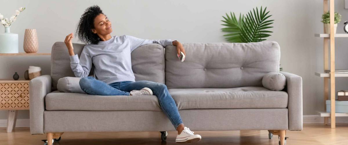 African american relaxed woman sitting on comfortable couch