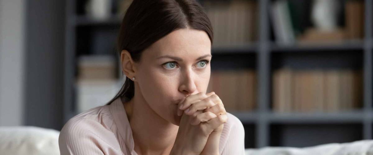 Stressed young woman sitting on couch