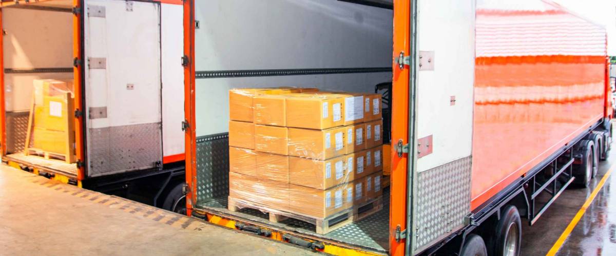 Cargo freight truck with boxes piled in the back.
