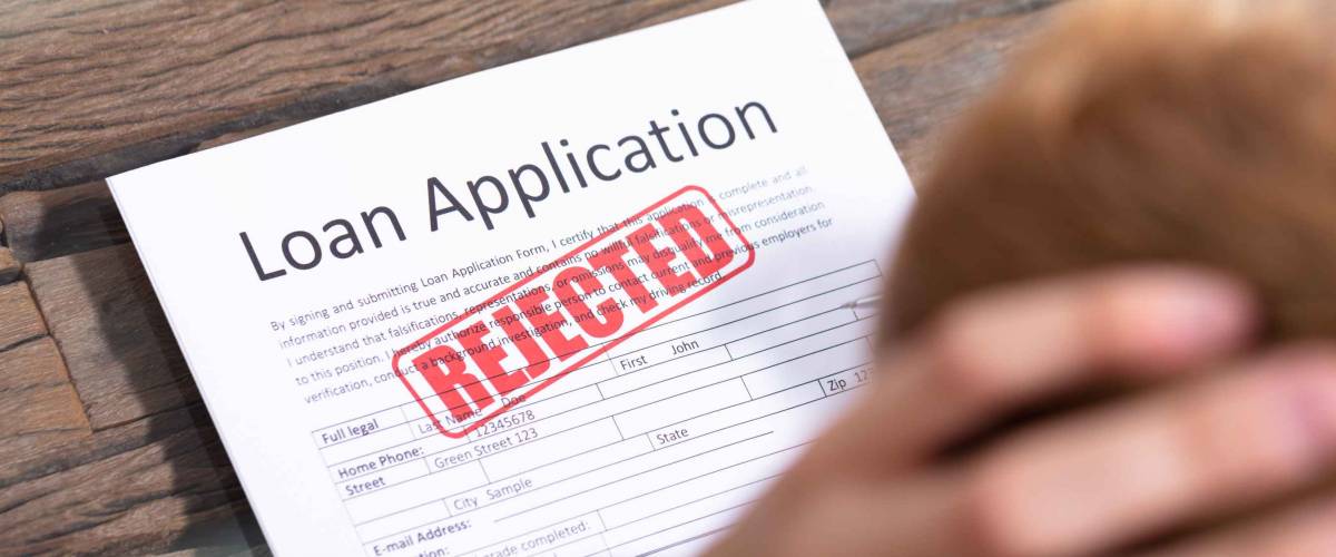 Stressed Person Looking At Rejected Loan Application