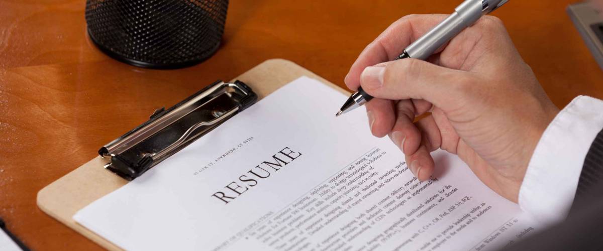 Person editing their resume with a pen.