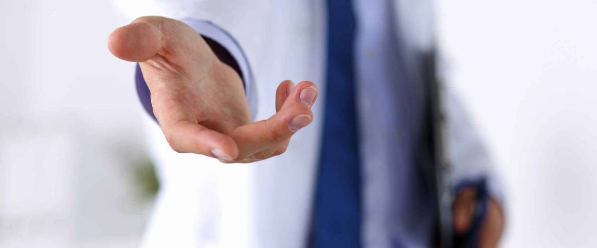 Male medicine doctor offering helping hand in office closeup. Friendly and cheerful gesture. Medical cure and tests advertisement concept. Physician ready to examine and save patient